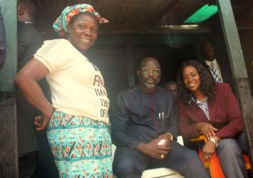 A Resident of Gilbratar poses with President Weah and First Lady Clar Marie Weah.EXECUTIVE MANSION