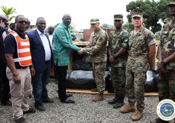 An officer of the US Military presenting tarpaulins to President Weah for use by the Armed Forces of LiberiaExecutive Mansion Photo